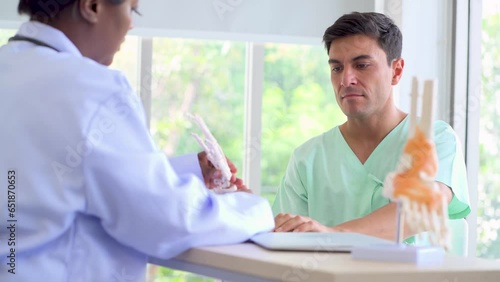 A male patient with bone problems in his back and wrist is receiving counseling and physical therapy from a doctor at the hospital. photo