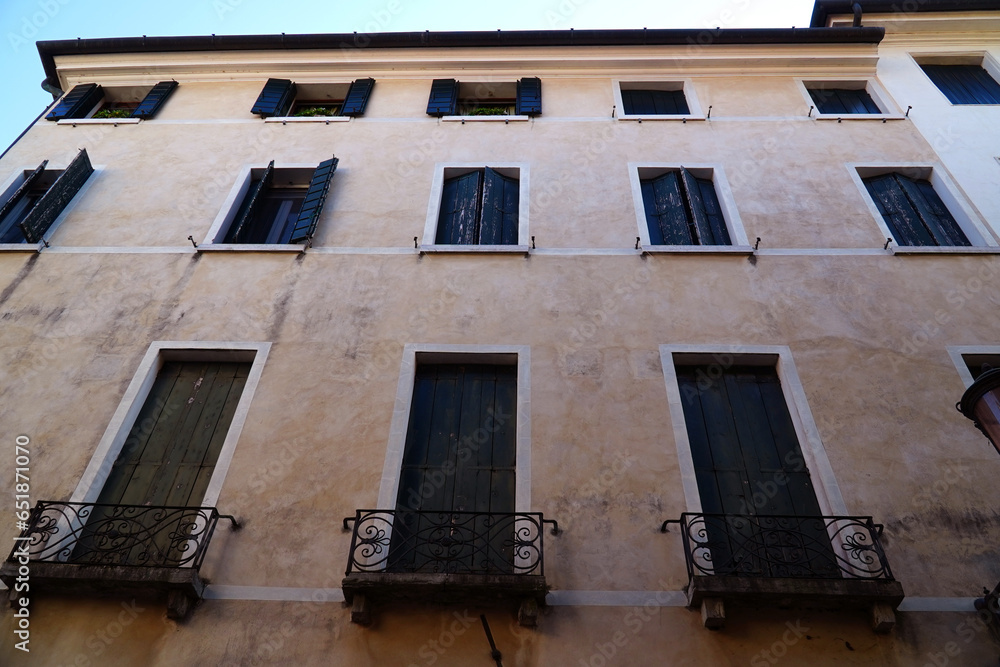 Obraz premium Window house facade with exterior wooden shutters in the historic center of Treviso in the Veneto region, Italy.