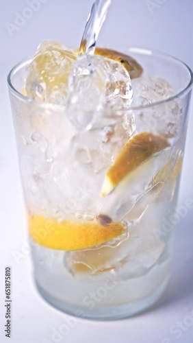 レモンを絞ったグラスにソーダを注ぐ