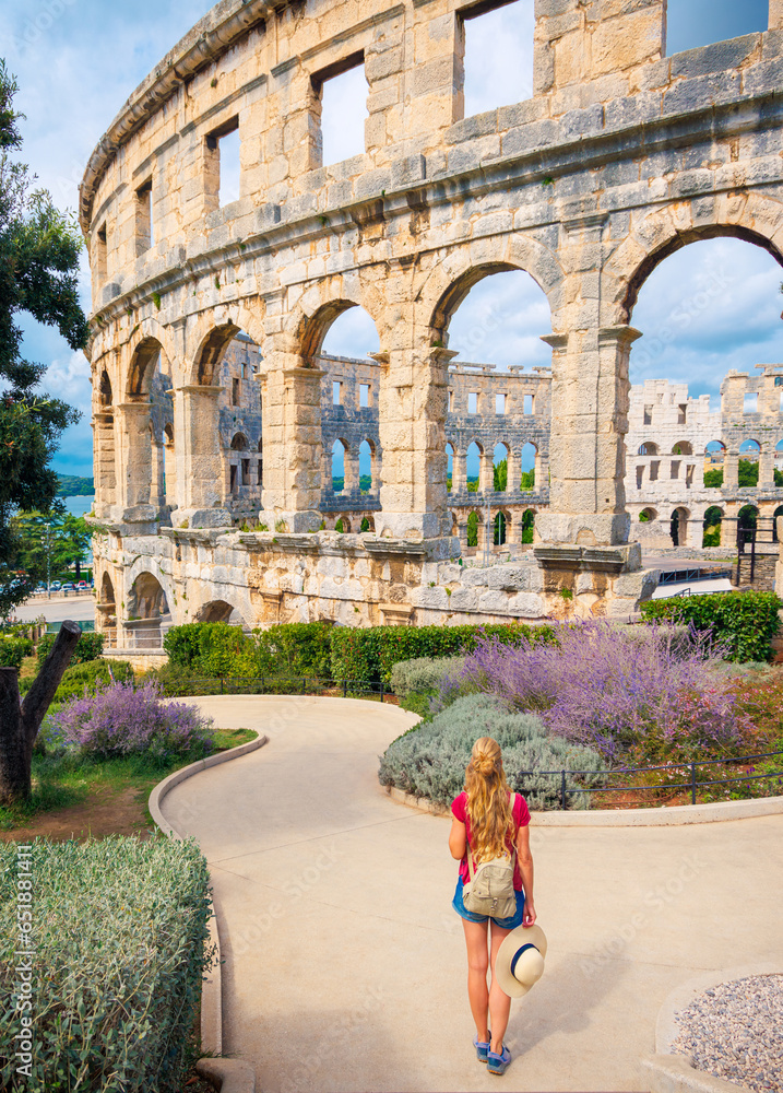 Rear view of woman tourist enjoying Pula city with ancient roman amphitheatre- Travel in Europe- Croatia