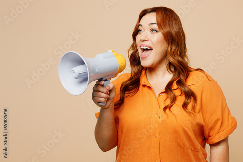 Young ginger chubby overweight woman wear orange shirt casual clothes hold megaphone scream announces discounts sale Hurry up isolated on plain pastel light beige background studio. Lifestyle concept.