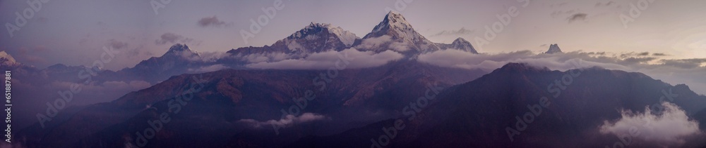 Panoramic view of the Himalayan mountain range with the world's highest peaks covered in snow at sunset