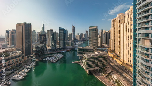 Aerial view to Dubai marina skyscrapers around canal with floating boats photo