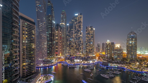 Dubai marina tallest skyscrapers and yachts in harbor aerial day to night.