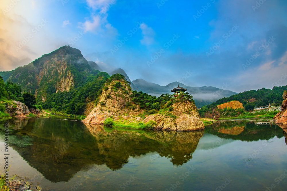 The pavilion is located on a mountain with a river below. The pavilion is located on a mountain with a river below.