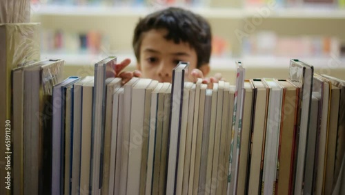 In a quiet, public library, a young child's insatiable curiosity leads to an enchanting exploration among bookshelves, creating a magical moment of literary wonder.