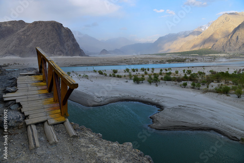 Wooden bridge on the edge of a mountain, located at the bank of Indus river in Skardu, this path leads to organic village, a famous tourist destination in Pakistan. photo