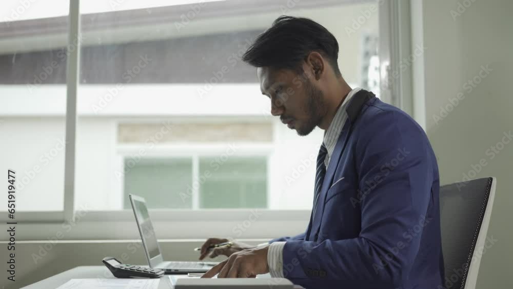 Young successful African American man working with financial documents and laptop charts, manager or customer checking financial documents sitting at table with laptop. Young successful African American man working with financial documents and laptop charts, manager or customer checking financial documents sitting at table with laptop.