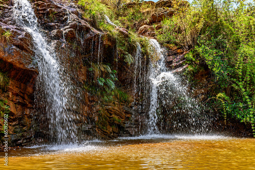 Waterfall among the rocks and vegetation in the Muaimii environmental reserve in the state of Minas Gerais