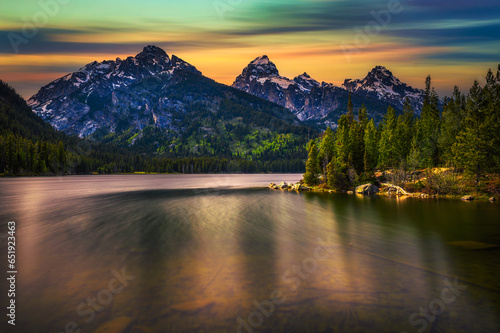 Sunset over Taggart Lake and Grand Teton Mountains in Wyoming, USA. Taggart Lake is a stunning alpine lake in Grand Teton National Park, surrounded by majestic mountains. Long exposure. photo