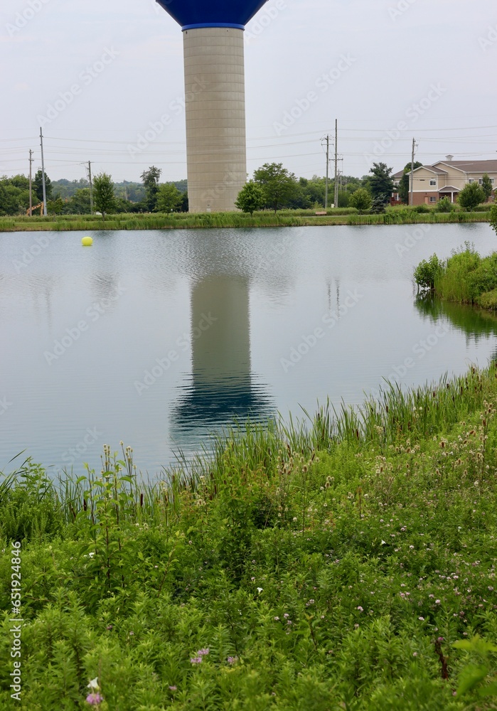 The reflection of the tall water tower in the lake. The reflection of the tall water tower in the lake.