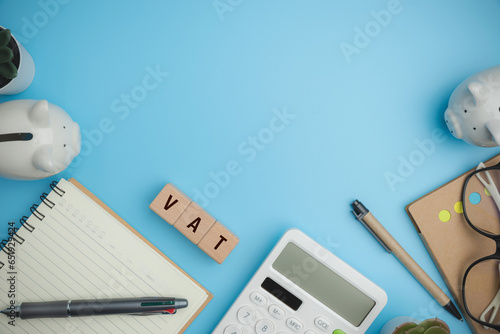 Top view VAT on wood cubes blocks on a blue background with copy space calculate annual taxes concept. Accounting, Vat, income tax. Calculation of taxes annual years.