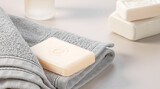 Bathroom accessories. Stack of gray soft towels and two bars of soap on a gray background