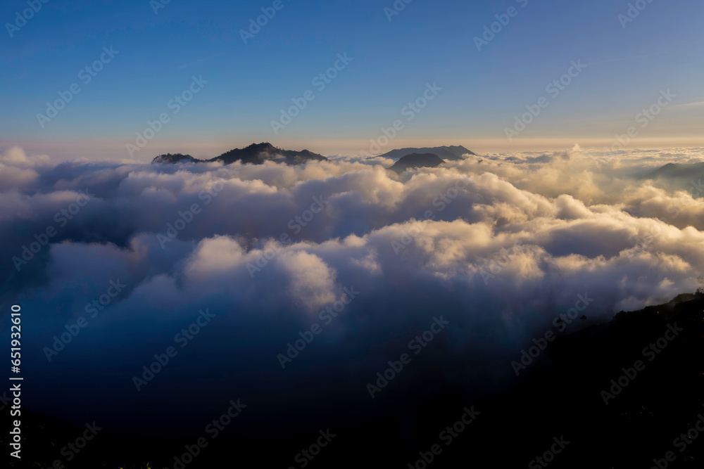 a sea of ​​clouds above a height with twilight spreading across the sky's horizon