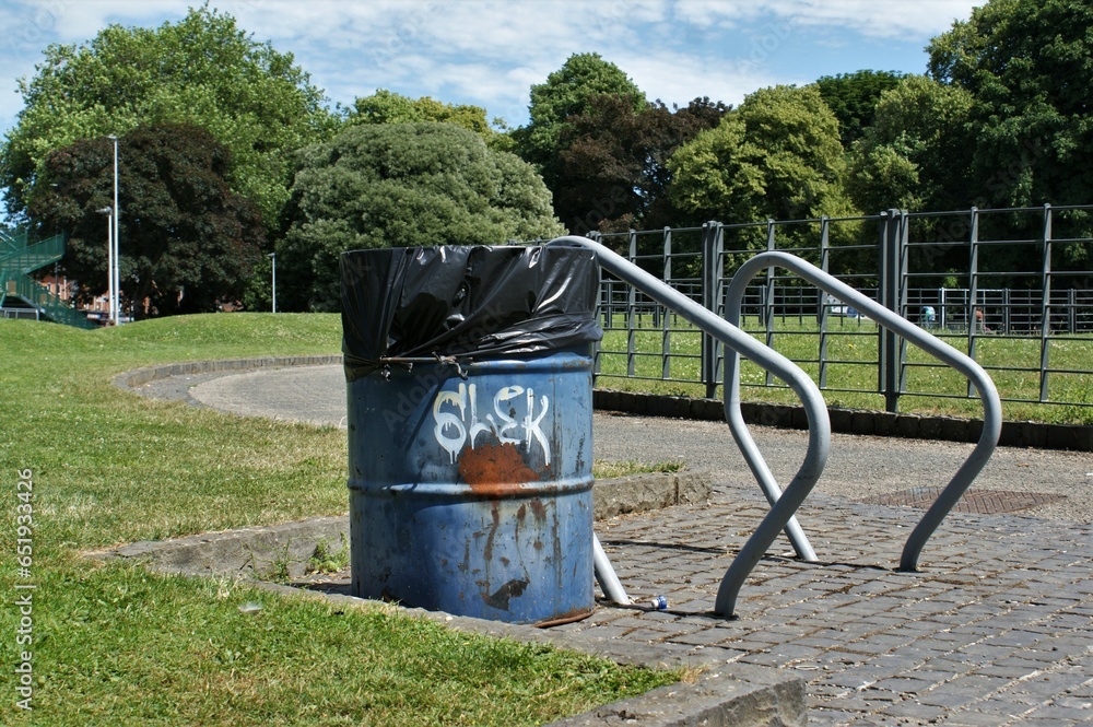 Trash can and bike shed in the park. A metal barrel as a trash can. Trash can and bike shed in the park. A metal barrel as a trash can.