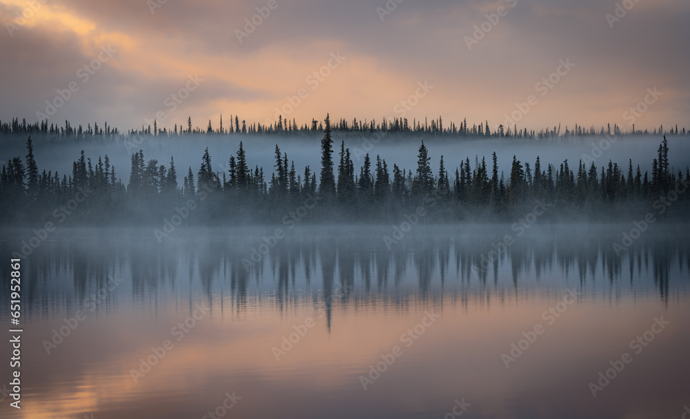 Sunrise over a lake in the boreal forest near the Nabesna Road in Wrangell St. Elias National Park, Alaska, USA. 
