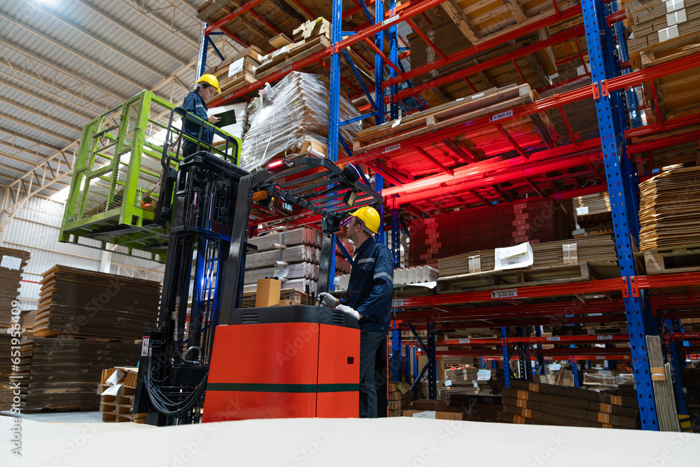 Male warehouse worker using forklift electric or electric pallet ...