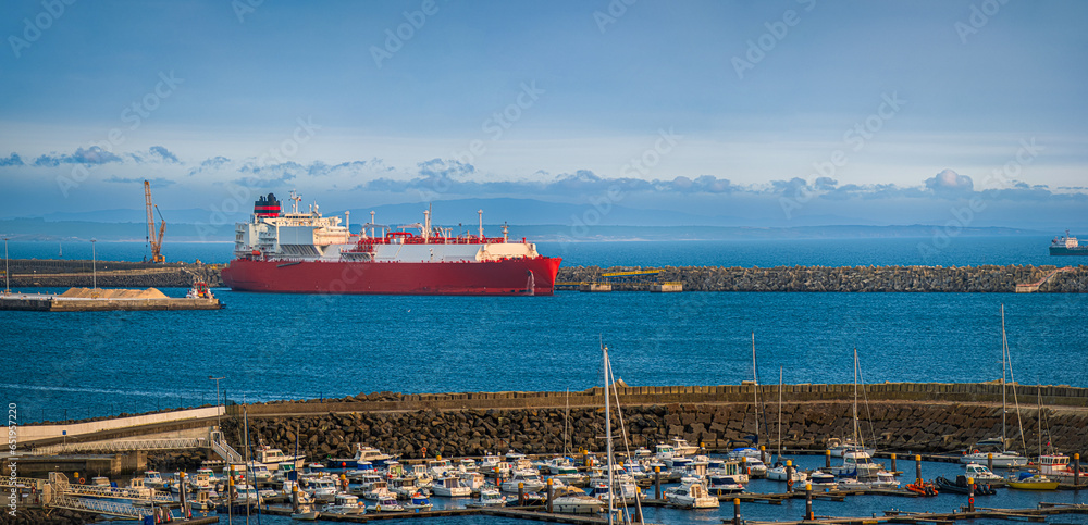 LNG carrier moored by pier in port on hazy evening.