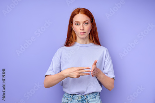 British sign language. A two-handed alphabet. Fingerspelling alphabet. red-haired woman showing deaf mute BSL alphabet, number 300 closeup portrait isolated blue background photo