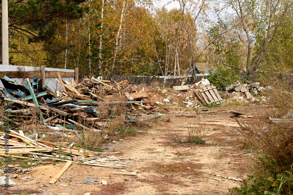 Waste wood and cross stakes.Dismantled old wooden fence. Garbage. Construction of a new house. Waste wood and cross stakes.Dismantled old wooden fence. Garbage. Construction of a new house.