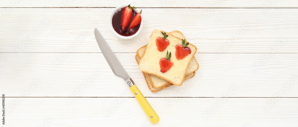Tasty toasts with sweet strawberry jam, butter and fresh berries on white wooden background Tasty toasts with sweet strawberry jam, butter and fresh berries on white wooden background
