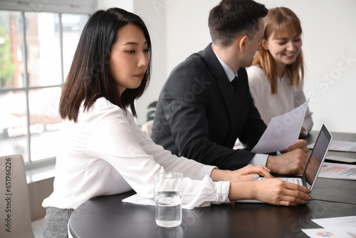 Female Asian business consultant working with laptop in office