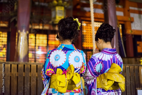 Japanese girls in beauty Kimono pray at Yasaka shrine at night, Kyoto