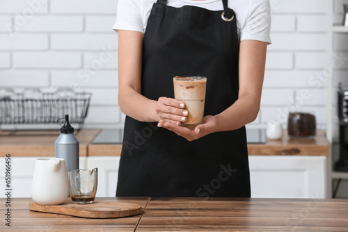 Barista in black apron hold...