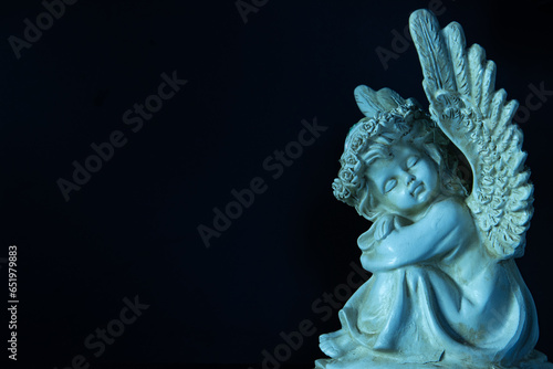 Photography of angel on black background.