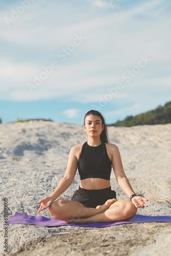 Beautiful woman doing yoga on the beach.