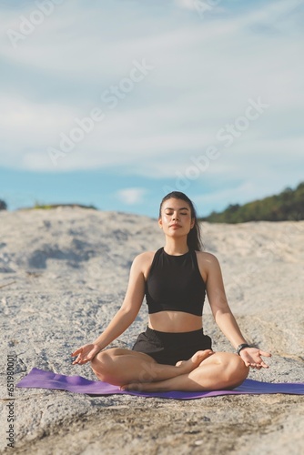 Beautiful woman doing yoga exercise on the beach.