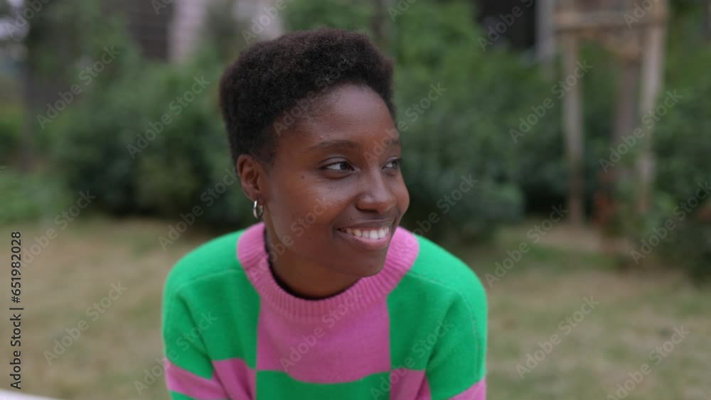 Close up portrait of young black woman sitting outdoors in city street. Positive african female waiting for someone outdoors. Close up portrait of young black woman sitting outdoors in city street. Positive african female waiting for someone outdoors.