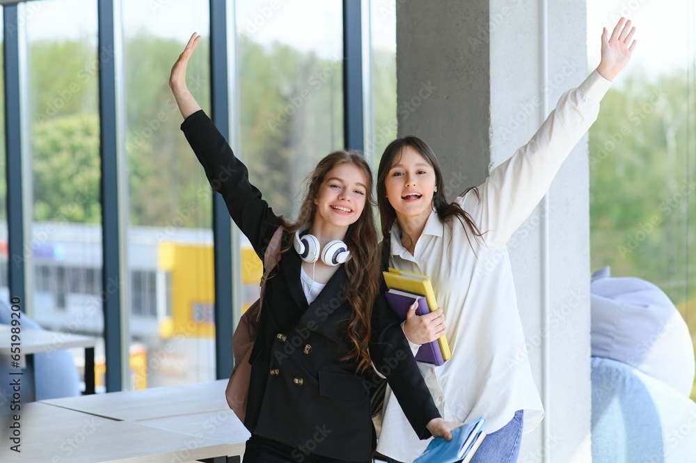 Two girlfriends girls schoolgirls. Happy girl students are satisfied with their studies. Well passed exams. Two girlfriends girls schoolgirls. Happy girl students are satisfied with their studies. Well passed exams.
