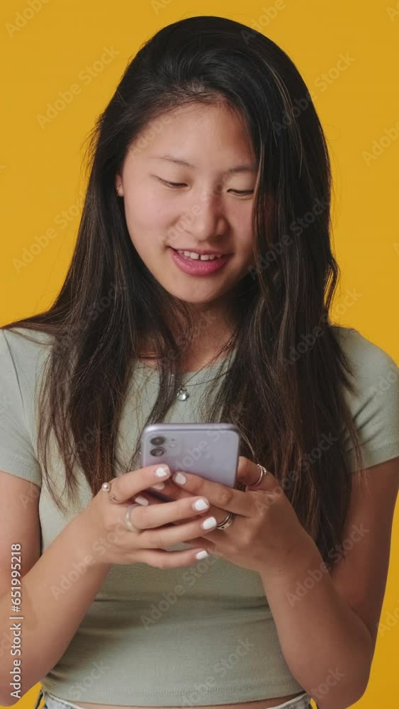 Smiling young woman using mobile phone isolated over white background in studio Smiling young woman using mobile phone isolated over white background in studio