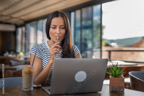 One woman sitting in cafe and holding electronic cigarette and working on laptop, modern lifestyle concept Free Download One woman sitting in cafe and holding electronic cigarette and working on laptop, modern lifestyle concept - GFXLoad