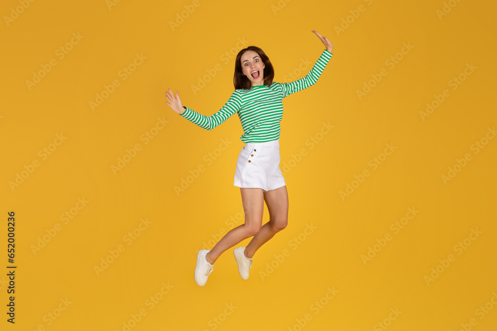 Emotional carefree young brunette woman jumping in the air Emotional carefree young brunette woman jumping in the air