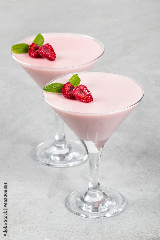 Vegan dessert. Raspberry cream jelly, Panna Cotta in a martini glass. Light gray background Vegan dessert. Raspberry cream jelly, Panna Cotta in a martini glass. Light gray background