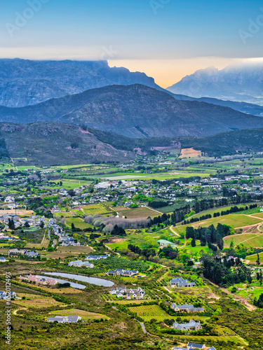 Aerial vertical shot of Franschhoek wine valley with mountains in the background during sunset, Western Cape, South Africa