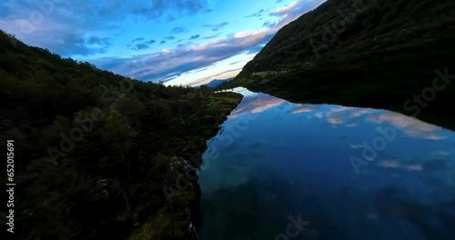 Flying over a lake reflecting a colourful sunset