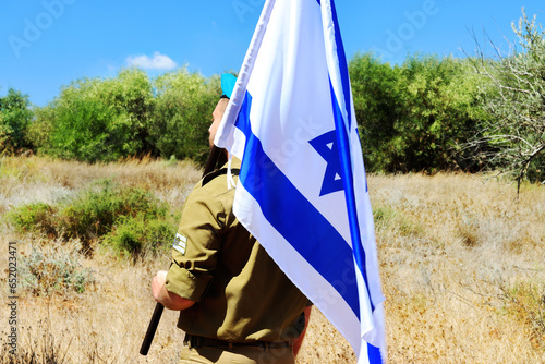 Israeli soldier with a large Israel Flag on his shoulder. Concepts photo: Israel Independence Day, IDF, Memorial Day, Jewish soldier photo