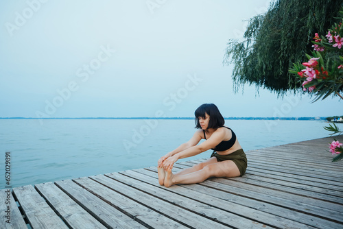 Woman at dawn doing yoga, body positivity © Anna Dzhurynska