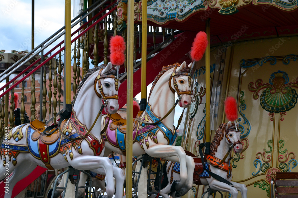 Colourful children's carousel with horses in an amusement park. Empty old fashioned carrousel. Merry-go-round in Gdansk, Poland
