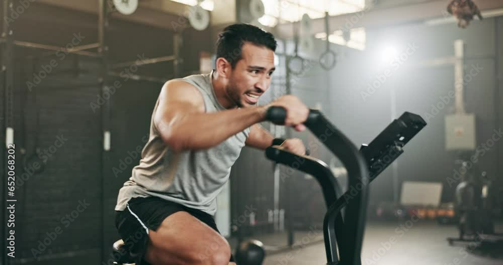 Asian man, fitness and cycling at gym in cardio workout, exercise or intense training on machine. Active male person on bicycle equipment in sweat or running for muscle, endurance or stamina at club Asian man, fitness and cycling at gym in cardio workout, exercise or intense training on machine. Active male person on bicycle equipment in sweat or running for muscle, endurance or stamina at club