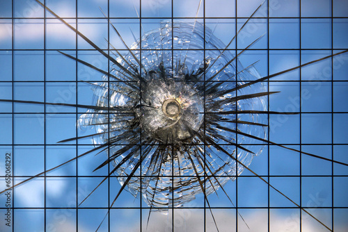 Bullet hole in a broken bulletproof glass, closeup image