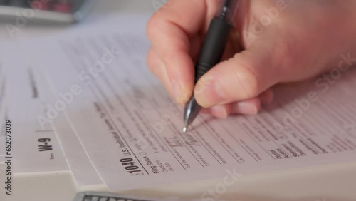 Female hands. they Completing tax declaration. Close up. Move camera photo