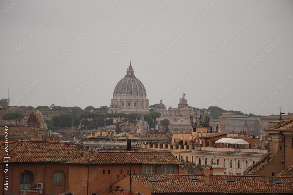 view of the city of Rome in Italy with St. Peter's Cathedral dome and city rooftops