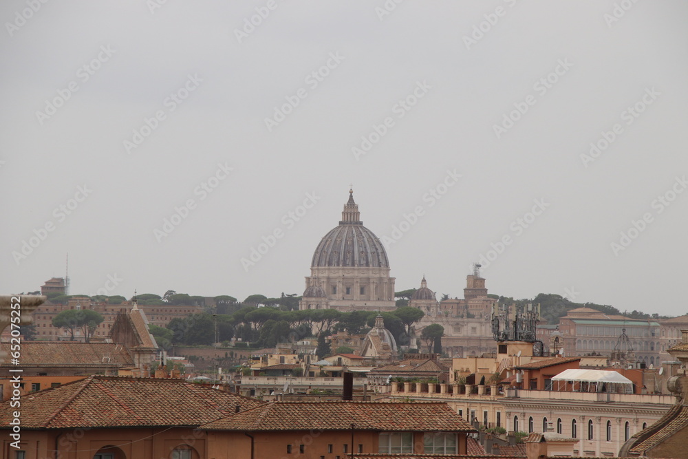 view of the city of Rome in Italy with St. Peter's Cathedral dome and city rooftops