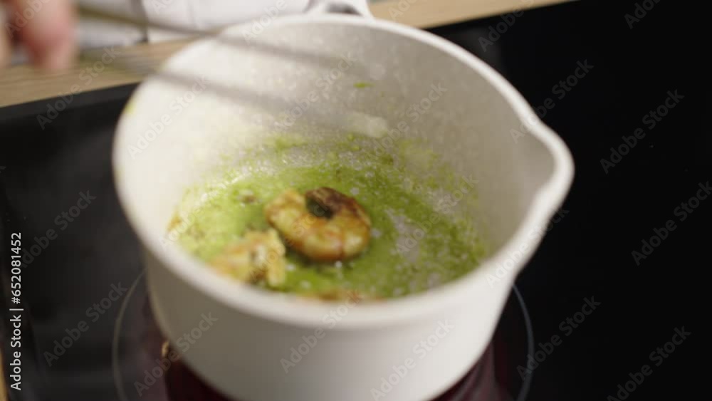 Close-up view of a chef frying shrimps with green garlic on the pan Close-up view of a chef frying shrimps with green garlic on the pan