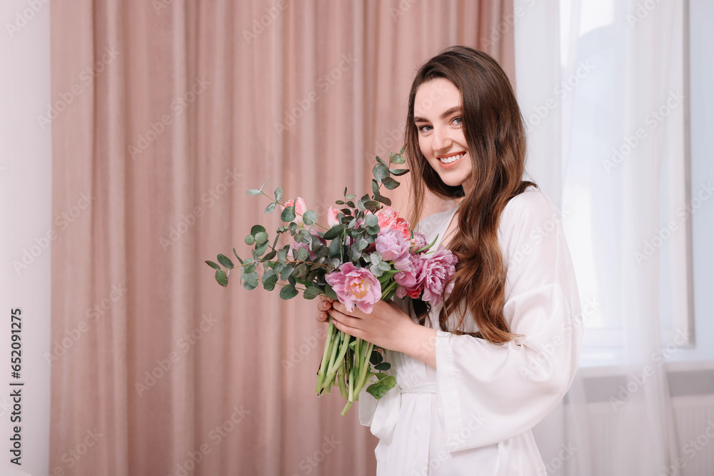 Beautiful happy young woman with bouquet of flowers indoors Beautiful happy young woman with bouquet of flowers indoors