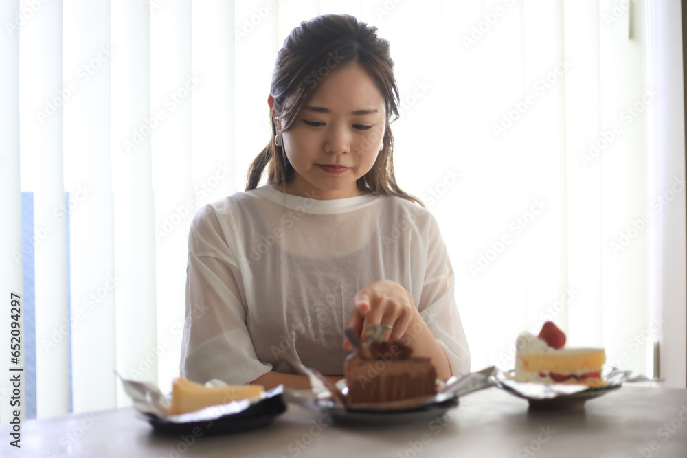 どのケーキを食べるか悩む女性 どのケーキを食べるか悩む女性